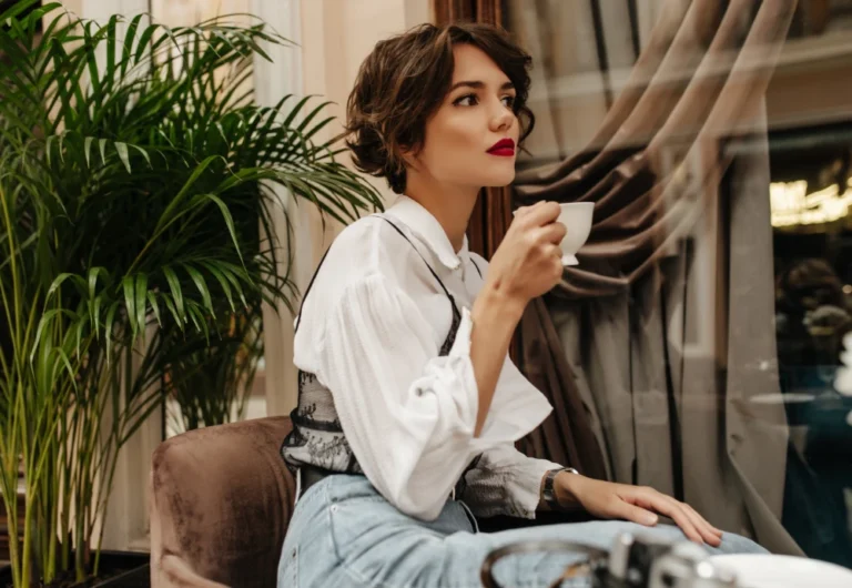 Woman sipping coffee in stylish cafe.