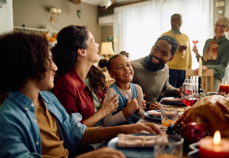 Family enjoying Thanksgiving dinner together, laughing.