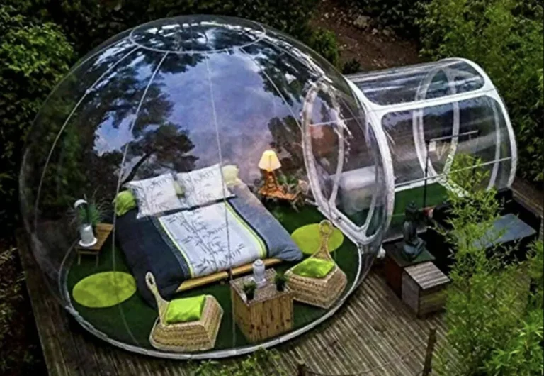 Transparent dome accommodation in lush garden setting.