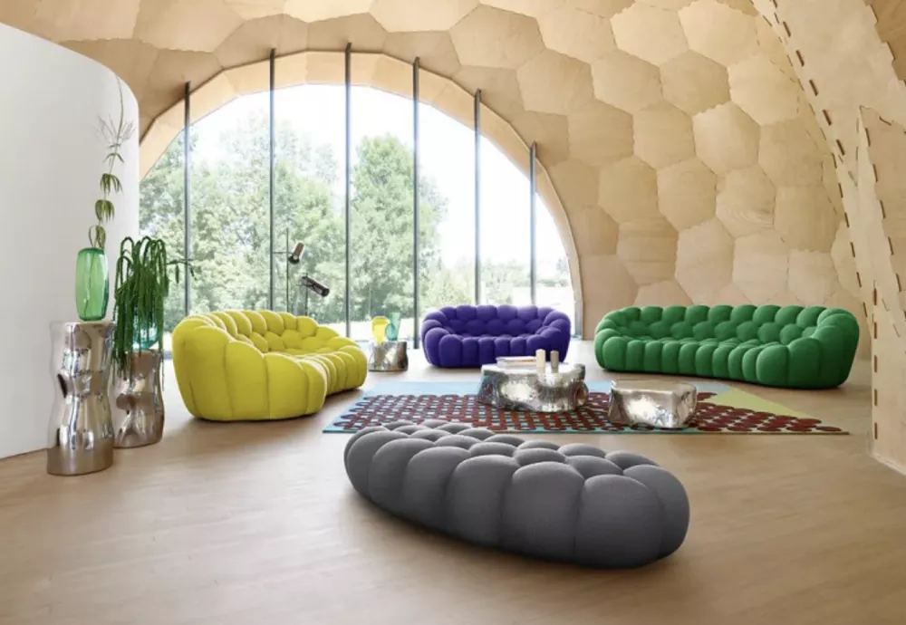 Colorful modern sofas in stylish arched room with large windows.