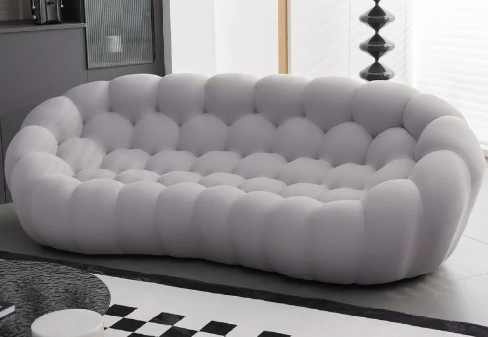 Modern gray tufted sofa in stylish living room.