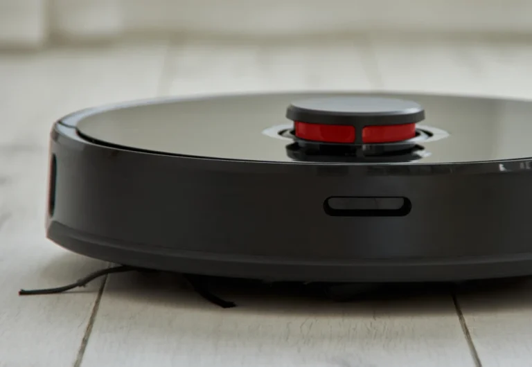 Robotic vacuum cleaner on wooden floor indoors.